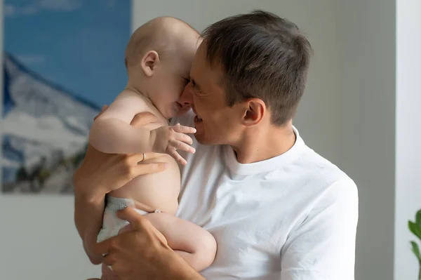 Ο πατέρας αγκαλιάζει νεογέννητο μωρό σε λευκό υπνοδωμάτιο. — Φωτογραφία Αρχείου