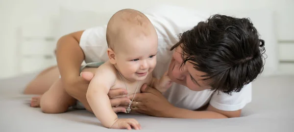 Szczęśliwa rodzina. Mama i dziecko bawią się i uśmiechają w łóżku — Zdjęcie stockowe