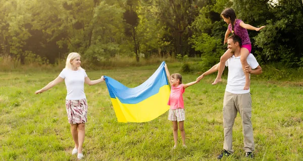 Familie mit der Fahne der Ukraine. Glücklicher Unabhängigkeitstag der Ukraine. Tag der Nationalflagge. Liebe zur Heimat und zu Symbolen. Kopierraum. — Stockfoto