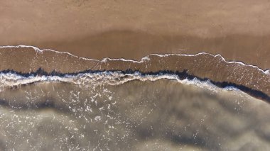 Doku dalgalarının üst görüntüsü kumlu sahil.