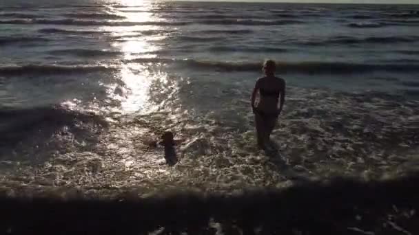 Matka a dcera si hrají na písečné pláži. Šťastná rodina na písečném pobřeží — Stock video