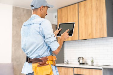 İşadamı mutfakta çalışmak için tablet kullanıyor. İş ve Teknoloji kavramı
