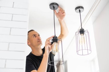İşçi evin tavanına lamba yerleştiriyor. Metin için boşluk