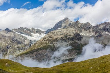 Bu nokta bulutların üstünde, bu bölgedeki diğer tepeleri çevreleyen....