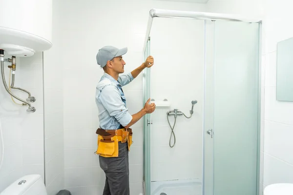 Rörmokare som installerar en duschkabin i badrummet — Stockfoto