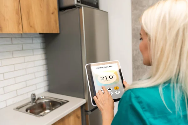 Rear view of young woman making setting of her home with online smart home application — Stock Photo, Image