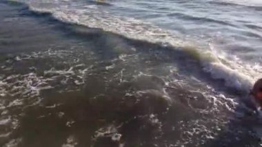 Anne ve kızı kumsalda oynuyorlar.