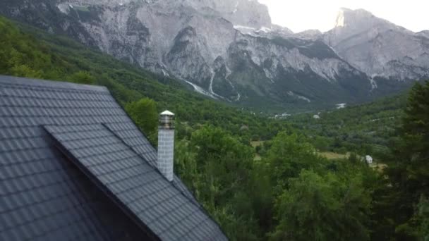 Theth National Park, Albânia. Vista aérea dos alpes albaneses ao nascer do sol. Voando sobre árvores verdes com vista para a aldeia de Thethi e montanhas majestosas. As montanhas amaldiçoadas na Albânia Prokletije — Vídeo de Stock