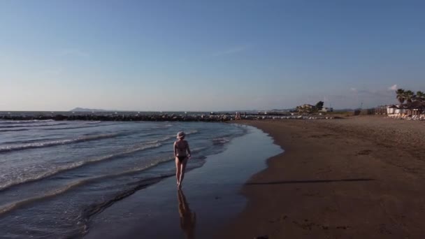 Een vrouw die met water speelt. Albanië, Ionische Zee. Vrouwelijke voeten, waterspatten — Stockvideo