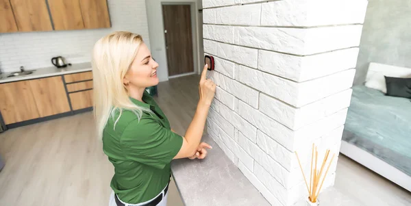 Mujer en casa usando termostato inteligente, sistema domestico de automatización — Foto de Stock