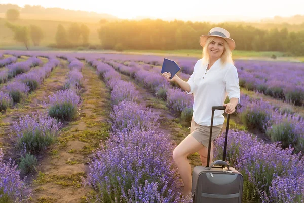 薰衣草地里拿着手提箱和护照的女人 — 图库照片