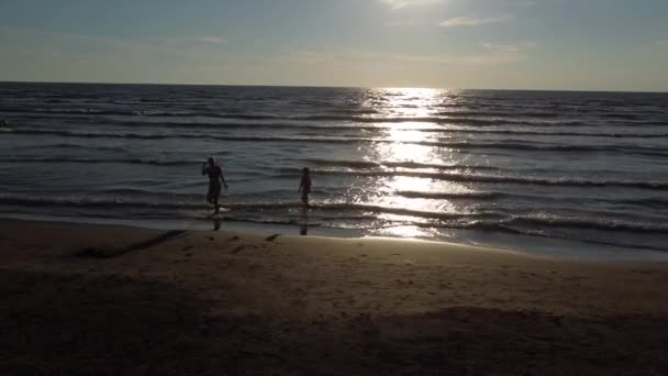 Anne ve kızı sahilde yürüyor. — Stok video