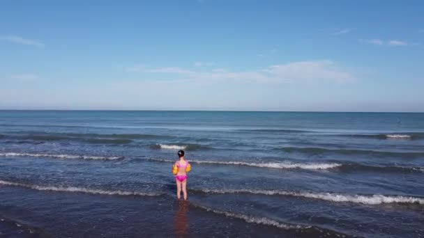 Deniz kıyısında yaz akşamında su kenarında oynayan çocuk. Kafkasyalı küçük kız kumsalda vakit geçiriyor. — Stok video