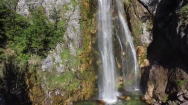 Arnavutluk 'un dağlarındaki Theth köyü yakınlarındaki güzel Theth şelalesi. Yavaş çekimde ormana çağlayan heybetli şelale, lanetli dağlar, Arnavutluk