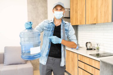 Teslimatçı adam koronavirüs pandemisi sırasında koruyucu yüz maskesi takıyor.