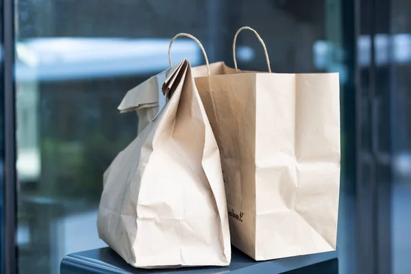 Bolsa de papel cerca de la puerta de la casa. Concepto de entrega segura. Entrega de comida a domicilio sin contacto. Medidas cautelares. —  Fotos de Stock