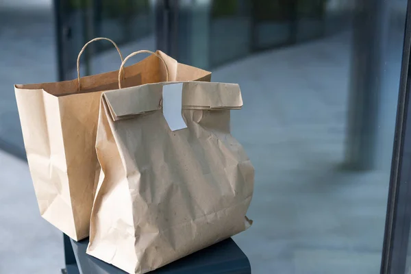 Sacchetto di carta vicino alla porta di casa. Concetto di consegna sicuro. Consegna di cibo a domicilio senza contatto. Misure cautelari. — Foto Stock