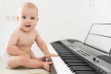 Adorable talented baby playing the piano clipart