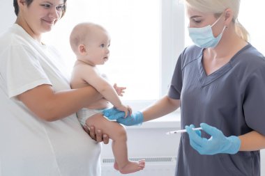Çocuk doktoru küçük çocuğa aşı yapıyor.