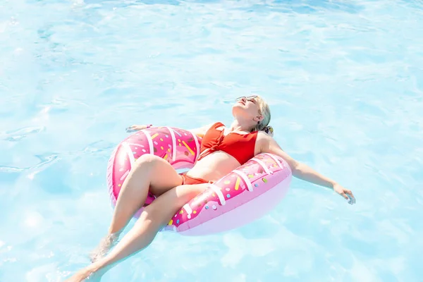 Vacanze estive. Godendo abbronzatura Donna in bikini sul materasso gonfiabile in piscina. — Foto Stock