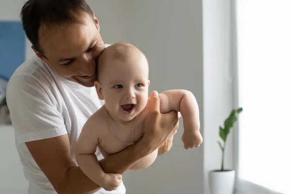 Apa ölelés Újszülött Baby fehér hálószobában. — Stock Fotó