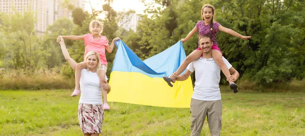 Щаслива родина з прапором України в польових умовах. спосіб життя — стокове фото