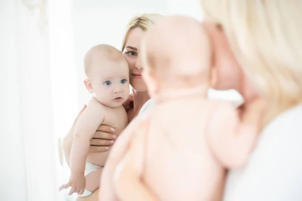 Atividade em Casa da Família. Mãe brincando com seu bebê bebê menino perto do espelho — Fotografia de Stock