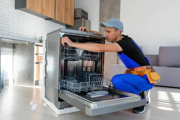 Worker repair dishwasher at home.