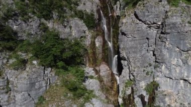 Arnavutluk 'un dağlarındaki Theth köyü yakınlarındaki güzel Theth şelalesi. Yavaş çekimde ormana çağlayan heybetli şelale, lanetli dağlar, Arnavutluk