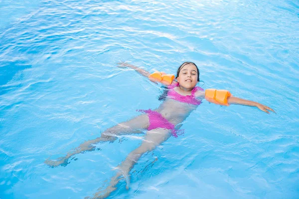 Petite fille s'amuser dans la piscine — Photo