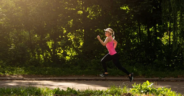 Довольно спортивная женщина бегает в парке — стоковое фото