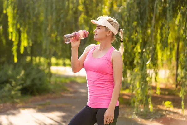 Deportiva mujer bebiendo agua al aire libre en día soleado — Foto de Stock