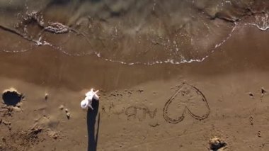 Suyla oynayan bir kadın. Arnavutluk, İyonik Deniz. Dişi ayakları, su sıçraması.