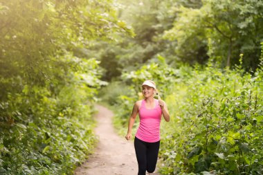 Kırsal bir yolda koşan genç bayan.