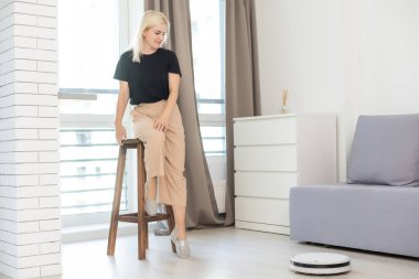 Modern oturma odasındaki ahşap zeminde robotik süpürge.