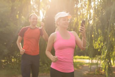Genç çift, bir kır yolu, egzersiz ve zindelik konsepti üzerinde koşarken sağlıklı bir yaşam tarzının keyfini çıkarıyor.