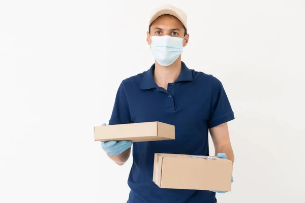 Man from delivery service in t-shirt, in protective mask and gloves giving food order and keping box over white background. — Φωτογραφία Αρχείου