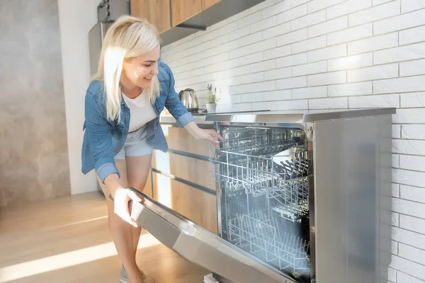 Woman putting dishes into dishwasher — Stock Photo, Image