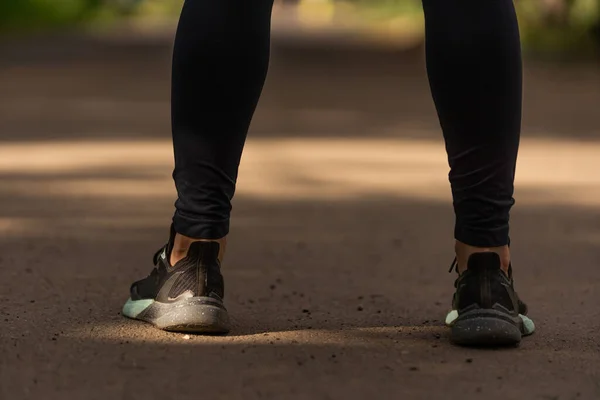 Pés de corredor correndo na estrada perto do sapato. mulher fitness sunrise jog workout welness conceito. — Fotografia de Stock