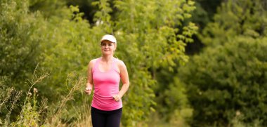 Kırsal bir yolda koşan genç bayan.