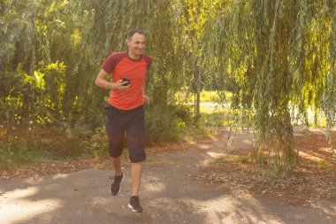 Sonbahar sabahı parkta koşan bir adam. Sağlıklı yaşam tarzı kavramı