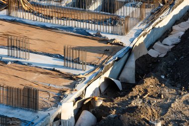 Bir sürü inşaat malzemesi, inşaat halindeki evler, vinçler ve işçiler olan büyük bir inşaat alanı. Hidrolik çekiçle yere çakılan kümeler. Metro inşaat projesi