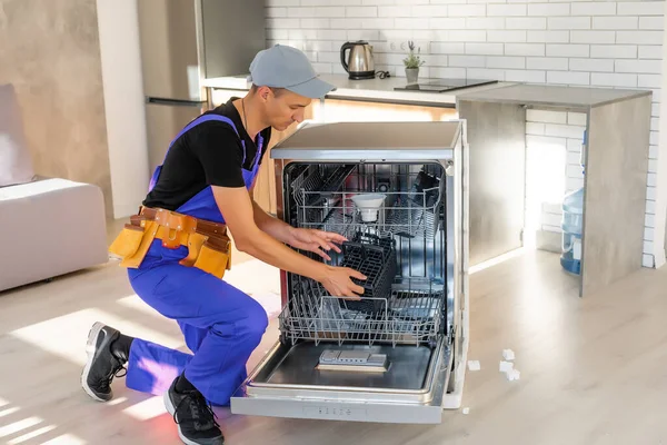 Master installing the dishwasher in a kitchen cabinet — Stock Photo, Image