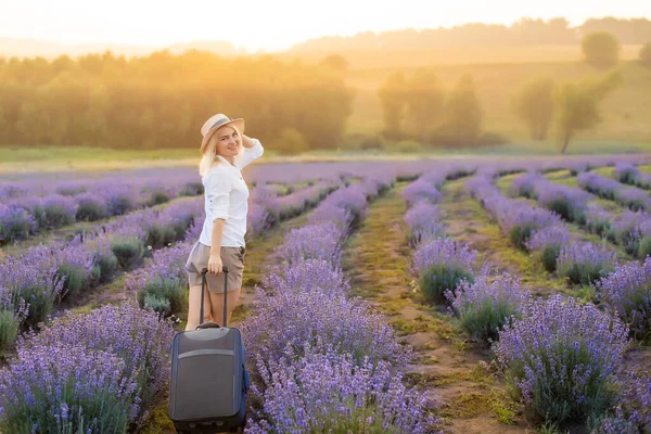 夏天的下午，一个女人带着手提箱在薰衣草地里 — 图库照片