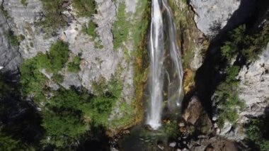 Arnavutluk 'un dağlarındaki Theth köyü yakınlarındaki güzel Theth şelalesi. Yavaş çekimde ormana çağlayan heybetli şelale, lanetli dağlar, Arnavutluk