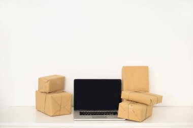 İşyerindeki dizüstü bilgisayar, küçük işletme sahibi, serbest çalışan, satıcı. Müşteriye teslim etmek için karton kutu ürün. Çevrimiçi satış, e-ticaret, paketleme, nakliye konsepti