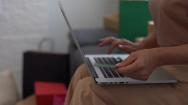 Kredi kartı sahibinin kadın elleri bankaya çevrimiçi ödeme yapıyor. İnternet mağazasında satın almak için laptop teknolojisi kullanan kadın tüketiciler. Ticaret web sitesi ödemeleri kavramı
