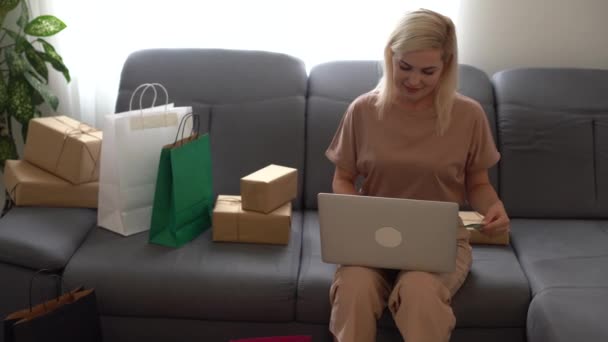 Kobieta przedsiębiorca sklep internetowy właściciel za pomocą laptopa w pracy przygotowanie skrzynek paczek sprawdzanie e-commerce post wysyłki detalicznej sklep internetowy e-commerce realizacji zamówienia w magazynie dostawy dropshipping — Wideo stockowe