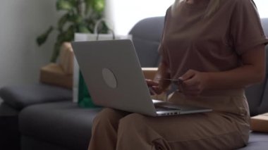 Kredi kartı sahibinin kadın elleri bankaya çevrimiçi ödeme yapıyor. İnternet mağazasında satın almak için laptop teknolojisi kullanan kadın tüketiciler. Ticaret web sitesi ödemeleri kavramı