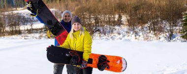 Kışın snowboard yapan bir aile.